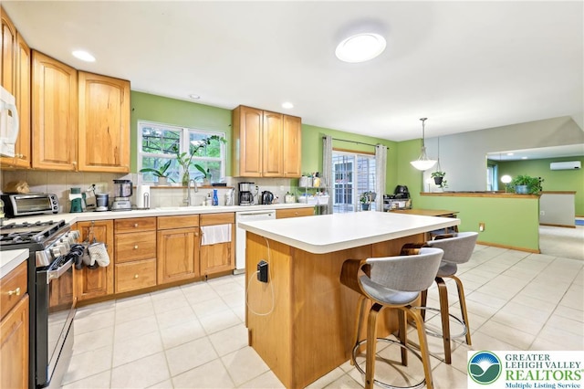 136 Outlook Ct, Middle Smithfield Twp, PA 18302 - kitchen with white appliances, a breakfast bar, a sink, backsplash, and a wall mounted air conditioner