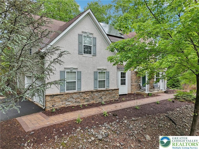 136 Outlook Ct, Middle Smithfield Twp, PA 18302 - view of front of home featuring stone siding, solar panels, stucco siding, and a shingled roof