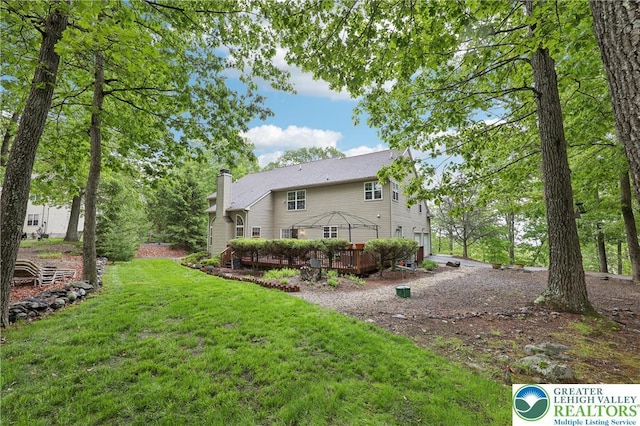 136 Outlook Ct, Middle Smithfield Twp, PA 18302 - rear view of house featuring a chimney, a wooden deck, and a lawn