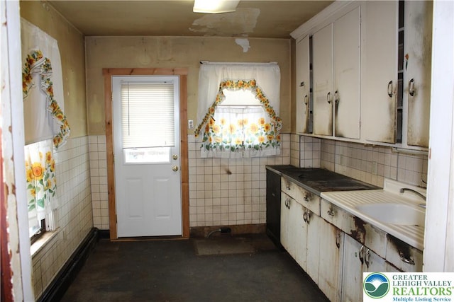 466 Franklin Ave, Palmerton Borough, PA 18071 - kitchen featuring tile walls, a sink, and white cabinetry