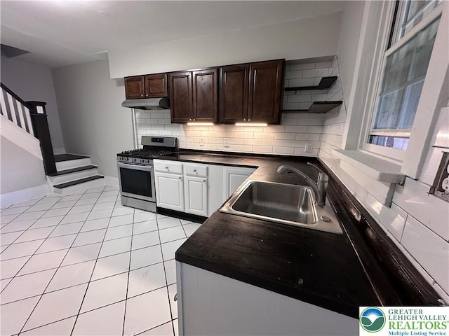 432 Schaffers Ct, Easton, PA 18042 - kitchen featuring stainless steel range with gas cooktop, under cabinet range hood, dark countertops, tasteful backsplash, and light tile patterned floors