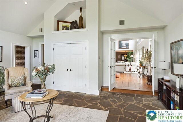 2965 Adams Way, Springfield Twp, PA 18077 - living room featuring high vaulted ceiling, stone flooring, and baseboards