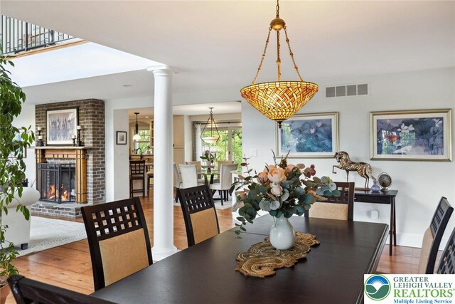 2965 Adams Way, Springfield Twp, PA 18077 - dining room with decorative columns, wood finished floors, a brick fireplace, and baseboards