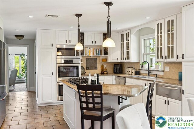2965 Adams Way, Springfield Twp, PA 18077 - kitchen featuring a warming drawer, stainless steel appliances, a kitchen island, tasteful backsplash, and a sink