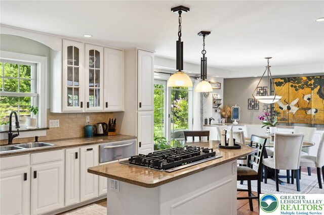 2965 Adams Way, Springfield Twp, PA 18077 - kitchen featuring a sink, a warming drawer, stainless steel gas cooktop, glass insert cabinets, and white cabinetry