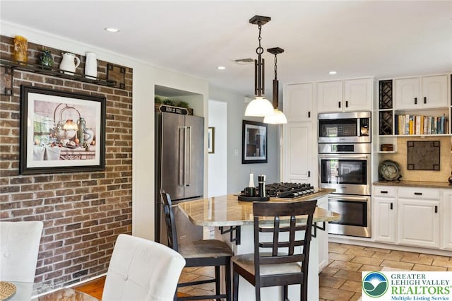 2965 Adams Way, Springfield Twp, PA 18077 - kitchen featuring appliances with stainless steel finishes, white cabinets, hanging light fixtures, light stone counters, and a center island