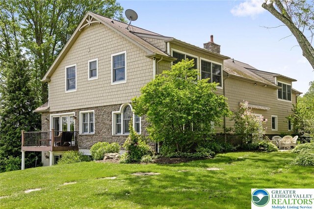 2965 Adams Way, Springfield Twp, PA 18077 - rear view of property featuring a chimney, a wooden deck, a yard, and stone siding