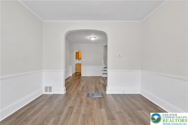 1123 Spruce St, Easton, PA 18042 - empty room featuring arched walkways, wood finished floors, ornamental molding, and baseboards