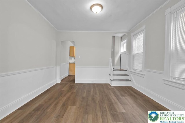 1123 Spruce St, Easton, PA 18042 - empty room with arched walkways, crown molding, dark wood-style floors, and baseboards