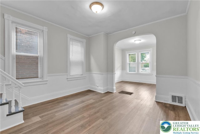 1123 Spruce St, Easton, PA 18042 - empty room featuring arched walkways, wood finished floors, crown molding, and wainscoting