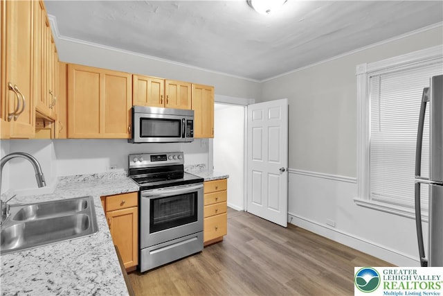 1123 Spruce St, Easton, PA 18042 - kitchen featuring stainless steel appliances, a sink, light brown cabinetry, light wood-type flooring, and ornamental molding
