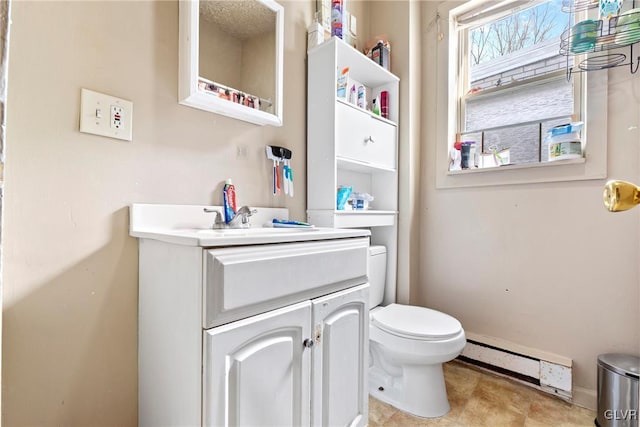 521 S Bradford St, Allentown City, PA 18109 - bathroom with a baseboard radiator, toilet, vanity, and baseboards