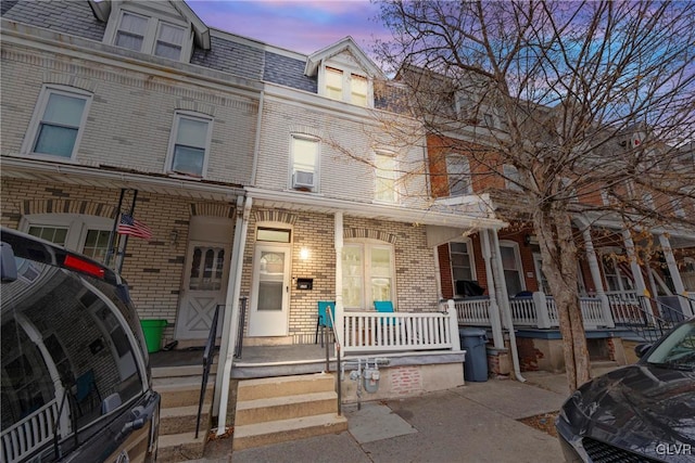526 N Law St, Allentown City, PA 18102 - view of property featuring brick siding, mansard roof, a porch, and cooling unit