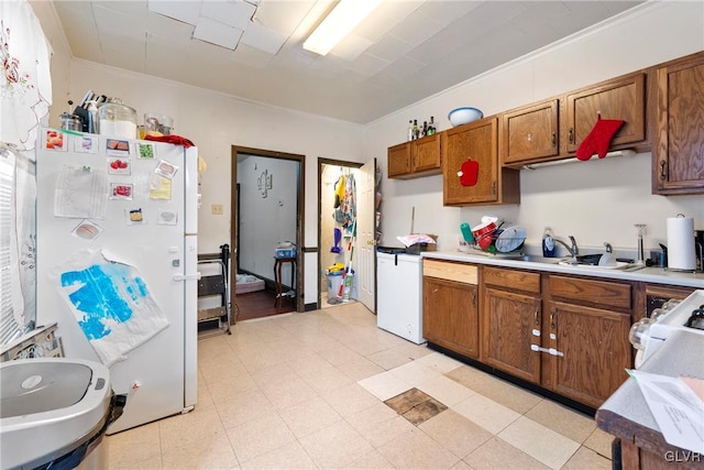 526 N Law St, Allentown City, PA 18102 - kitchen with freestanding refrigerator, a sink, light countertops, brown cabinetry, and range