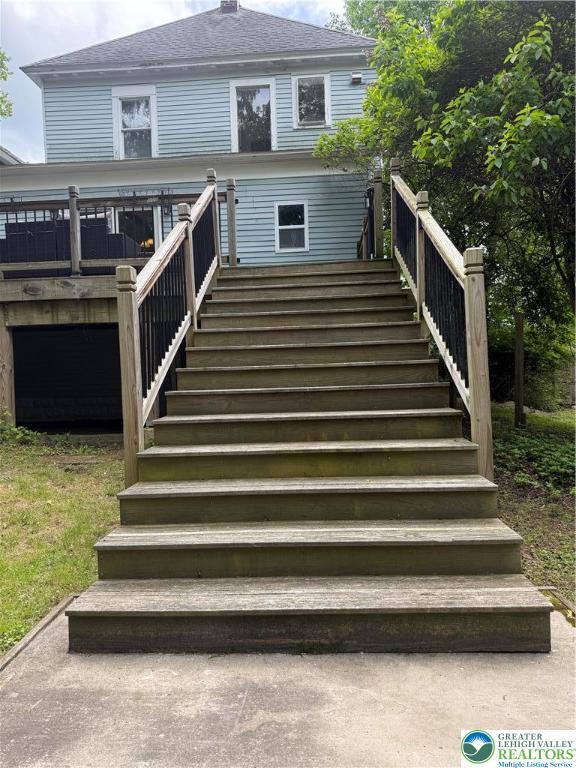 204 Analomink St, East Stroudsburg, PA 18301 - back of property with stairway, a wooden deck, a shingled roof, and a chimney