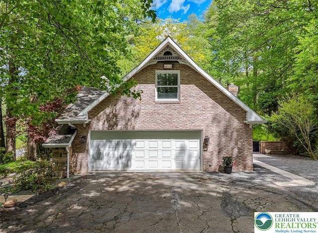 711 E Center St, Nesquehoning Borough, PA 18240 - view of front of house with asphalt driveway, brick siding, a chimney, and a garage