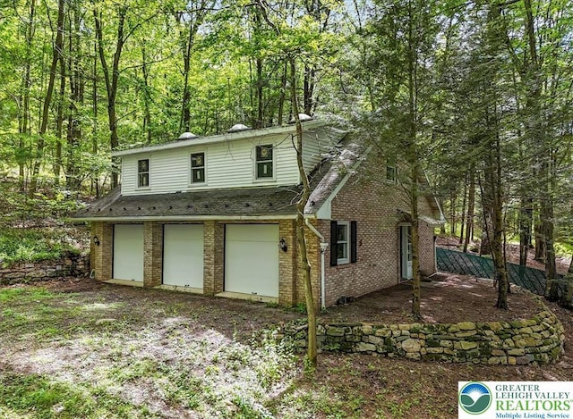 711 E Center St, Nesquehoning Borough, PA 18240 - view of front facade with an attached garage, brick siding, and a view of trees