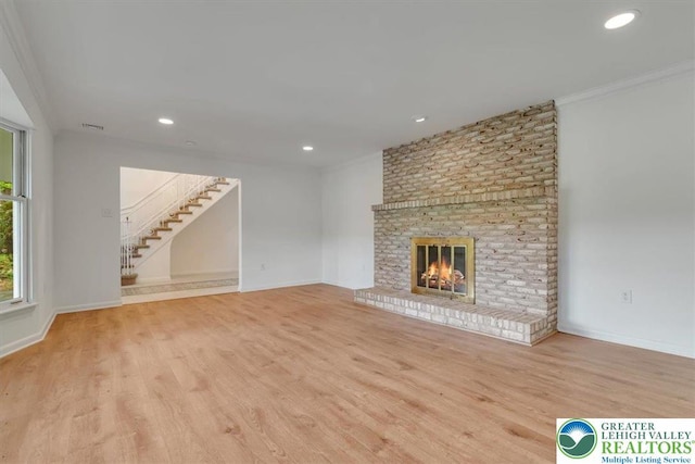 711 E Center St, Nesquehoning Borough, PA 18240 - unfurnished living room featuring wood finished floors, a brick fireplace, stairway, recessed lighting, and crown molding