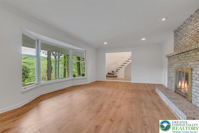 711 E Center St, Nesquehoning Borough, PA 18240 - unfurnished living room with healthy amount of natural light, a brick fireplace, light wood-type flooring, ornamental molding, and recessed lighting
