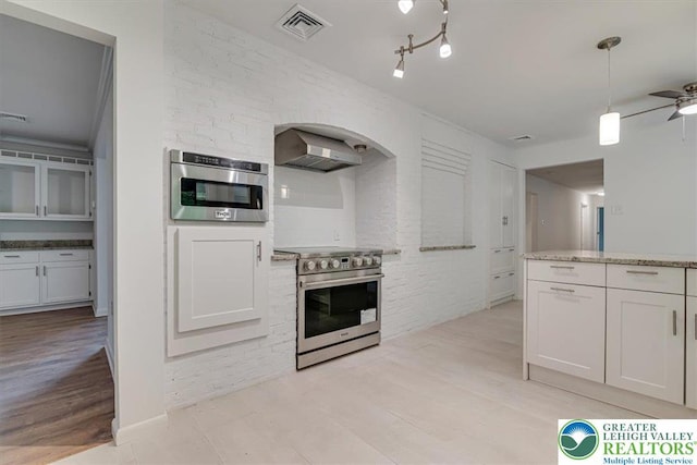 711 E Center St, Nesquehoning Borough, PA 18240 - kitchen featuring stainless steel range with electric cooktop, wall chimney range hood, light wood-style flooring, ceiling fan, and arched walkways