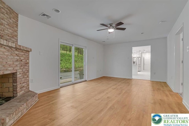 711 E Center St, Nesquehoning Borough, PA 18240 - unfurnished living room with ceiling fan, light wood-style flooring, baseboards, and a brick fireplace