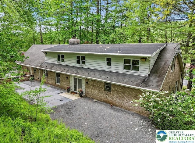 711 E Center St, Nesquehoning Borough, PA 18240 - rear view of property featuring a patio, a chimney, and a shingled roof