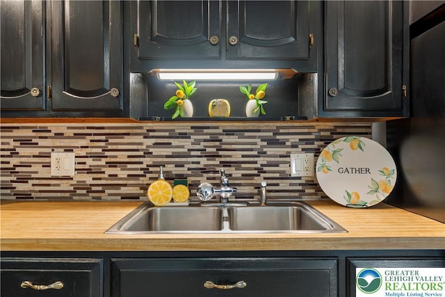 929 Webster Ave, Allentown City, PA 18103 - kitchen with dark cabinets, a sink, decorative backsplash, and light countertops