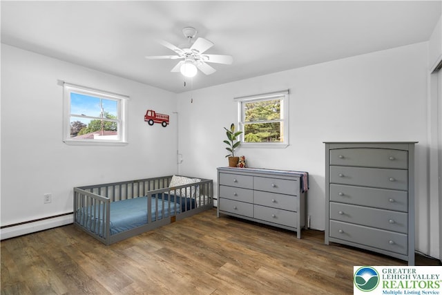 929 Webster Ave, Allentown City, PA 18103 - bedroom featuring a nursery area, wood finished floors, baseboard heating, and a ceiling fan