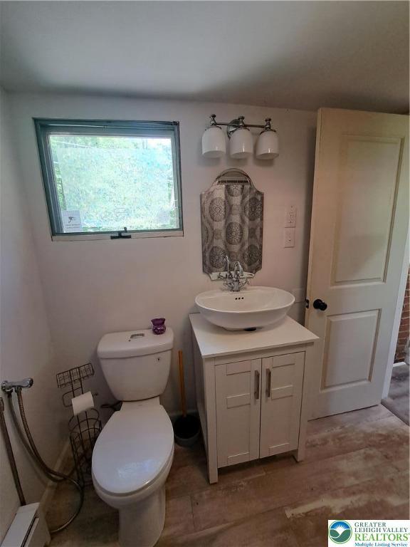 1392 Cherrylane Rd, Stroud Twp, PA 18301 - bathroom featuring vanity, baseboard heating, plenty of natural light, and toilet