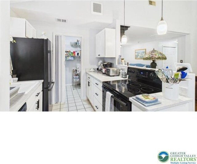 108 Abbey Ln, Lehman Twp, PA 18302 - kitchen with black / electric stove, freestanding refrigerator, light tile patterned flooring, and white cabinetry