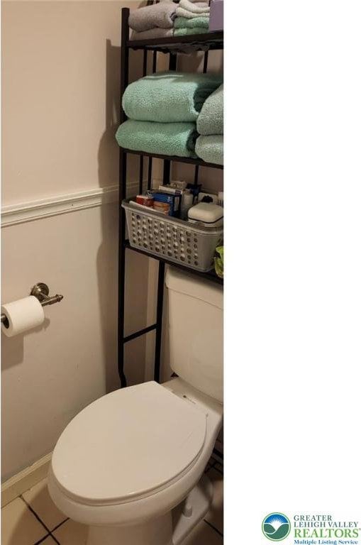 108 Abbey Ln, Lehman Twp, PA 18302 - half bathroom featuring toilet, tile patterned flooring, and a wainscoted wall