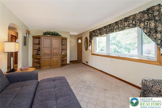 217 26th St, Allentown City, PA 18104 - living area featuring arched walkways, baseboards, and light colored carpet