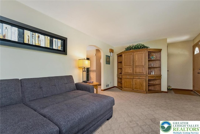 217 26th St, Allentown City, PA 18104 - living room featuring arched walkways, light colored carpet, and baseboards
