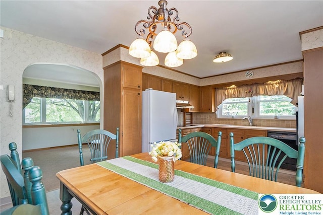 217 26th St, Allentown City, PA 18104 - dining space with a chandelier, wallpapered walls, arched walkways, and light colored carpet