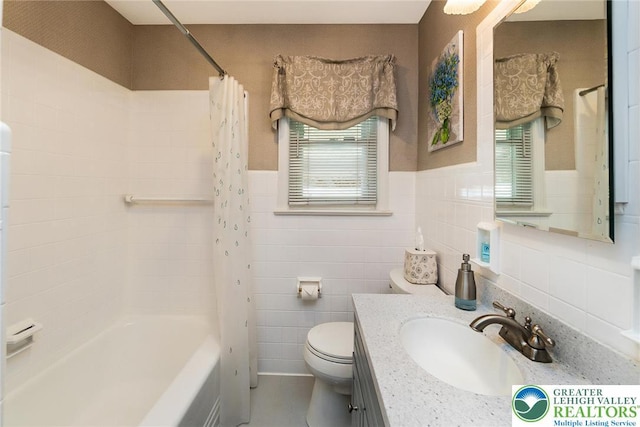 217 26th St, Allentown City, PA 18104 - full bath featuring vanity, toilet, shower / bath combo, a wainscoted wall, and tile walls