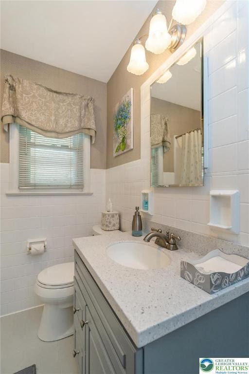 217 26th St, Allentown City, PA 18104 - full bathroom with tile walls, vanity, toilet, tile patterned floors, and a shower with shower curtain