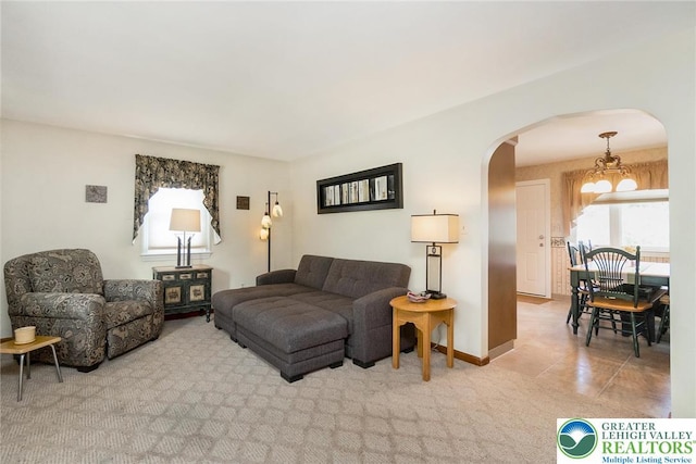 217 26th St, Allentown City, PA 18104 - carpeted living room with arched walkways, a chandelier, and baseboards