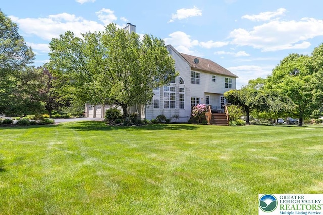 140 Birdie Way, Eldred Twp, PA 18058 - rear view of house featuring a lawn, a chimney, and a garage