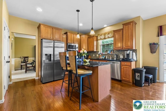 140 Birdie Way, Eldred Twp, PA 18058 - kitchen with stainless steel appliances, tasteful backsplash, dark wood-style floors, a center island, and a kitchen breakfast bar