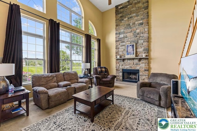 140 Birdie Way, Eldred Twp, PA 18058 - living area with a towering ceiling, healthy amount of natural light, a stone fireplace, baseboards, and ceiling fan