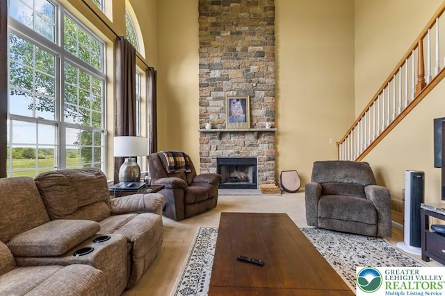 140 Birdie Way, Eldred Twp, PA 18058 - carpeted living room featuring a high ceiling, a stone fireplace, and stairs