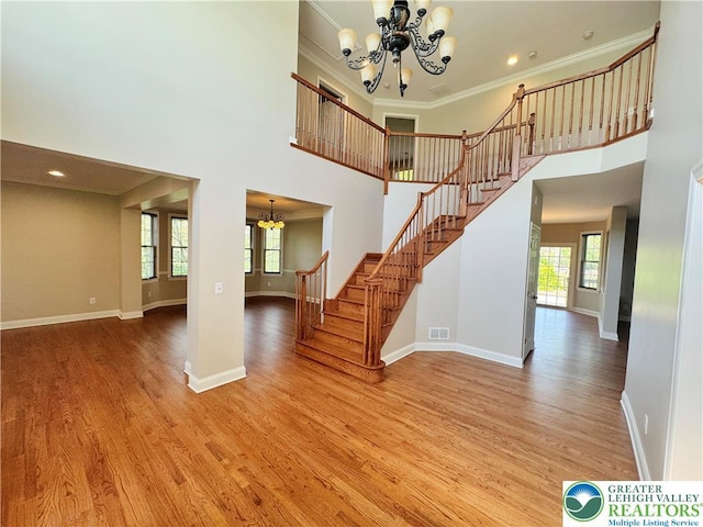 4620 Graystone Dr, Lower Nazareth Twp, PA 18064 - entryway featuring a chandelier, a towering ceiling, light wood-type flooring, stairs, and ornamental molding