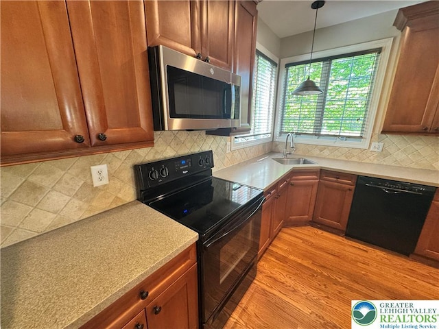 4620 Graystone Dr, Lower Nazareth Twp, PA 18064 - kitchen with black appliances, pendant lighting, light wood-type flooring, decorative backsplash, and light countertops