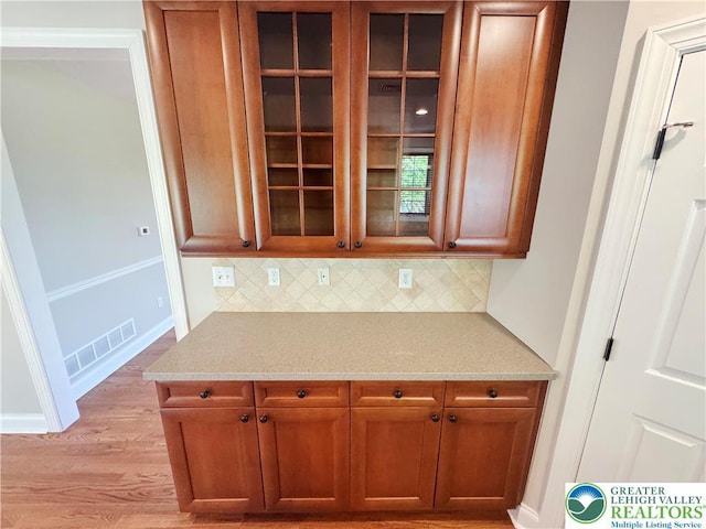 4620 Graystone Dr, Lower Nazareth Twp, PA 18064 - kitchen with backsplash, light wood finished floors, brown cabinets, and glass insert cabinets