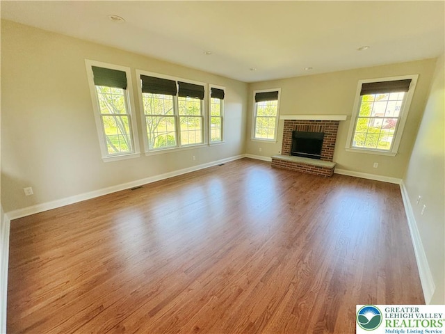 4620 Graystone Dr, Lower Nazareth Twp, PA 18064 - unfurnished living room with healthy amount of natural light, wood finished floors, and a fireplace