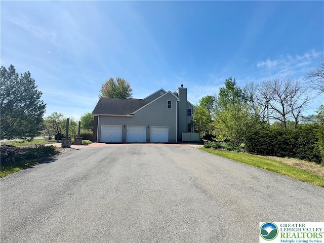 4620 Graystone Dr, Lower Nazareth Twp, PA 18064 - view of front of home with a chimney, asphalt driveway, and a garage