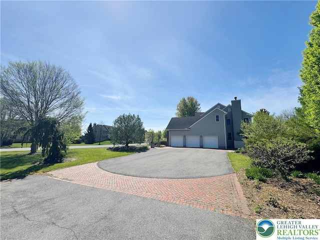 4620 Graystone Dr, Lower Nazareth Twp, PA 18064 - view of front facade with asphalt driveway, a garage, a chimney, and a front yard