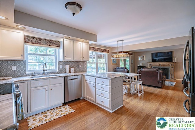 3624 Mcintosh Dr, North Whitehall Twp, PA 18069 - kitchen featuring appliances with stainless steel finishes, a sink, light wood finished floors, white cabinetry, and a fireplace