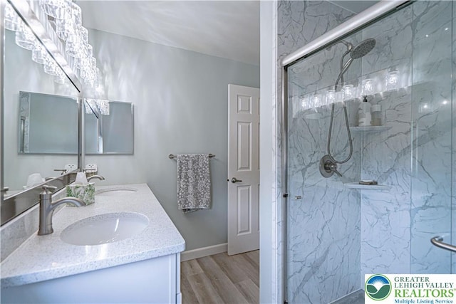 3624 Mcintosh Dr, North Whitehall Twp, PA 18069 - bathroom with wood finished floors, double vanity, a marble finish shower, and baseboards