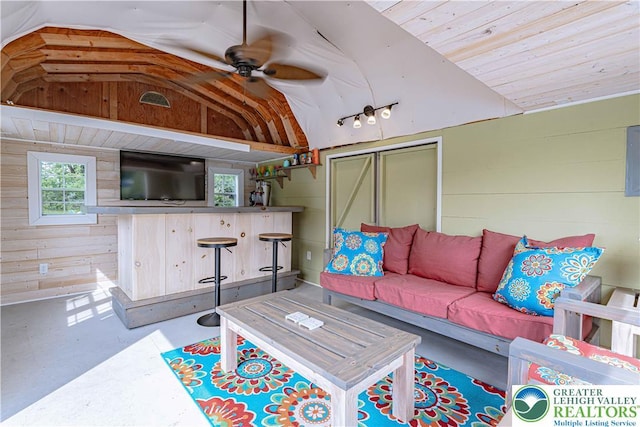 3624 Mcintosh Dr, North Whitehall Twp, PA 18069 - living area featuring lofted ceiling, finished concrete floors, wood walls, and ceiling fan